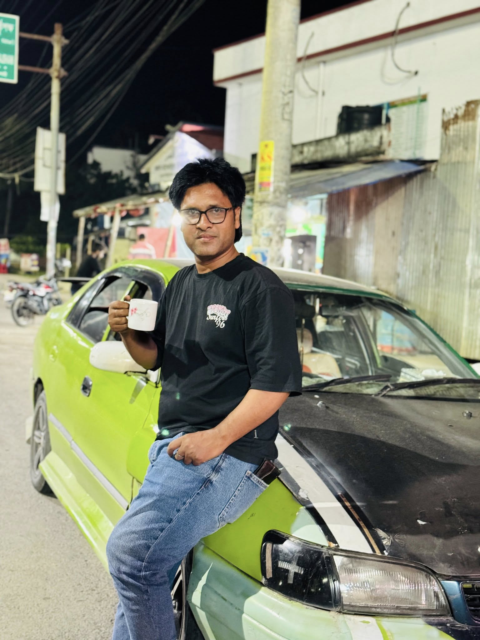 Lime-green Toyota Corolla E100 training car used by Famous Driving Center in Rajshahi.